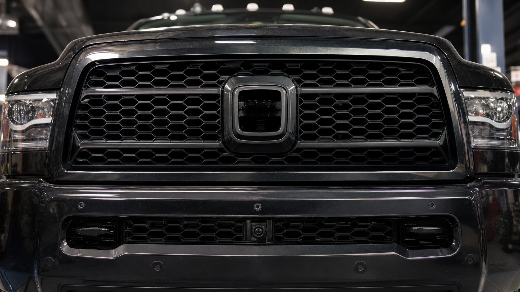 Ram 2500 front grille detail with camera and parking-sensor fitment areas visible.